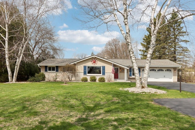 ranch-style home featuring a garage, a front lawn, aphalt driveway, and stucco siding
