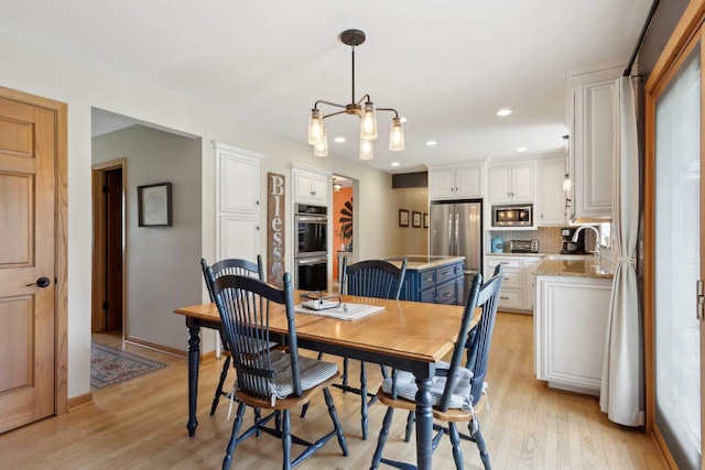 dining room featuring a toaster, baseboards, light wood finished floors, a notable chandelier, and recessed lighting