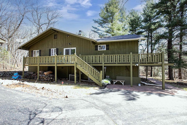 rear view of house featuring a wooden deck and stairs