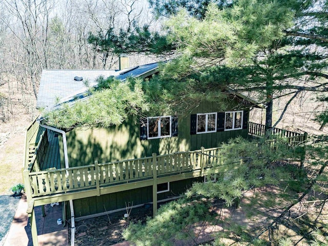 rear view of house featuring a chimney and a deck