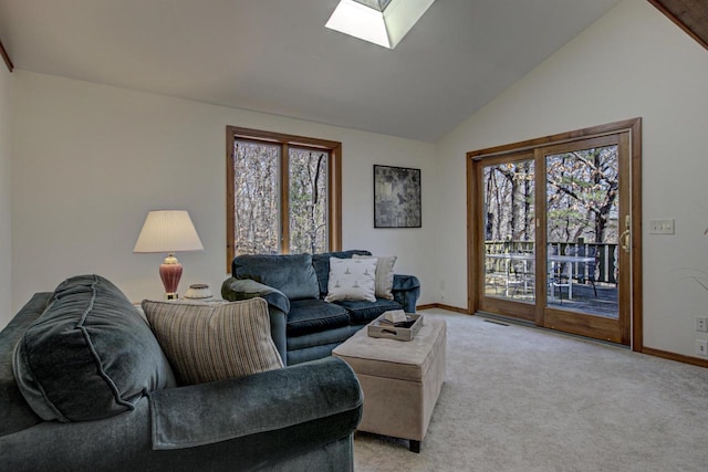 living area featuring baseboards, a wealth of natural light, and lofted ceiling with skylight