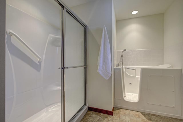 full bath featuring a garden tub, baseboards, and a stall shower