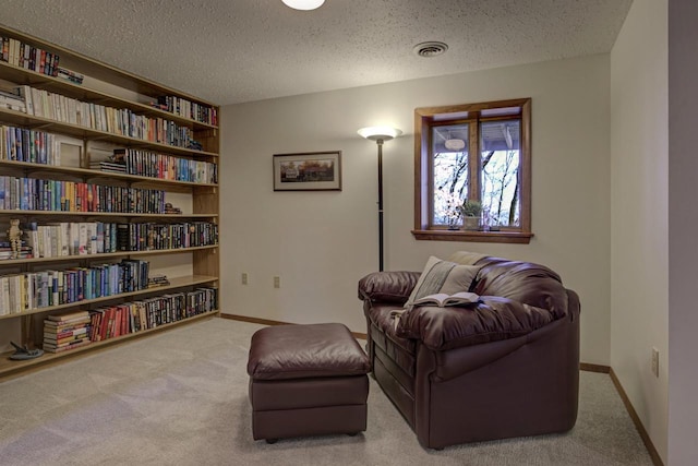 living area with a textured ceiling, baseboards, and carpet