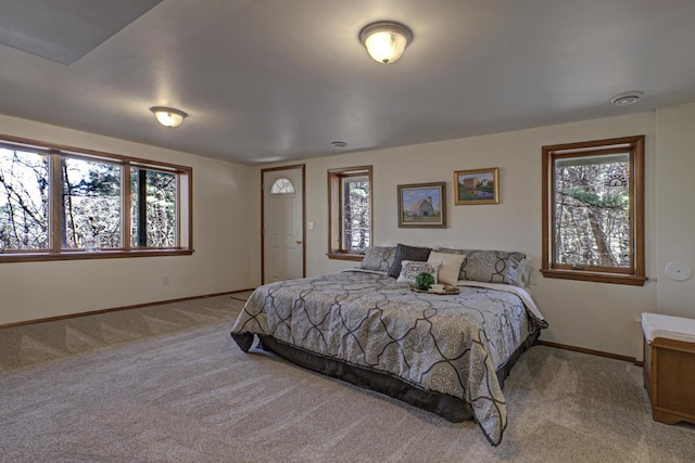 bedroom featuring baseboards, multiple windows, and carpet flooring