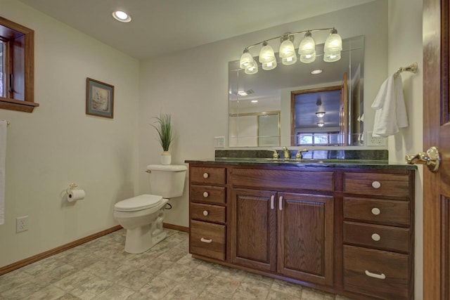 full bathroom featuring vanity, baseboards, a shower stall, and toilet