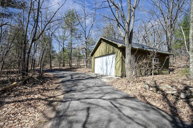 exterior space with an outdoor structure and aphalt driveway
