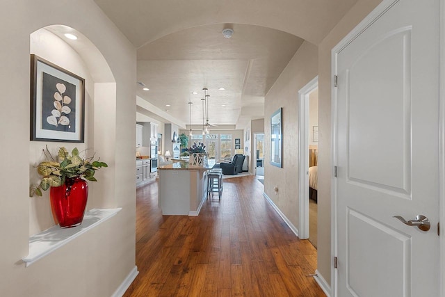 hall featuring recessed lighting, baseboards, and dark wood-style floors