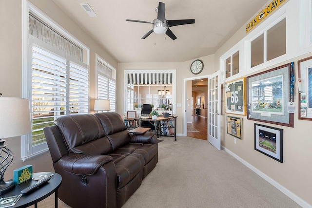 carpeted living area featuring plenty of natural light, a ceiling fan, baseboards, and visible vents