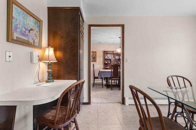 dining space with baseboard heating, baseboards, light carpet, and light tile patterned floors