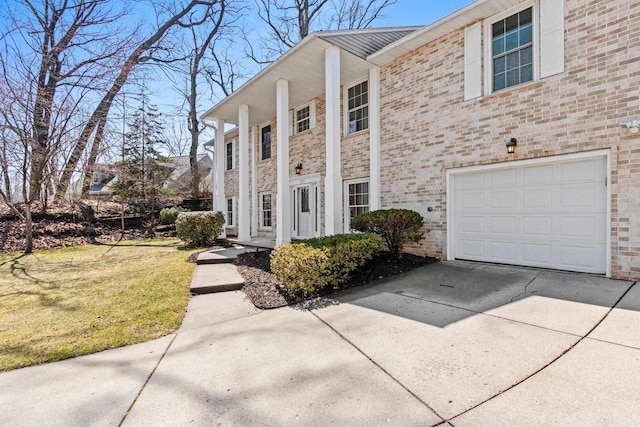 view of front of property with an attached garage, a front lawn, brick siding, and concrete driveway