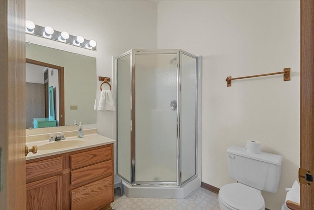 full bathroom featuring vanity, a stall shower, and toilet