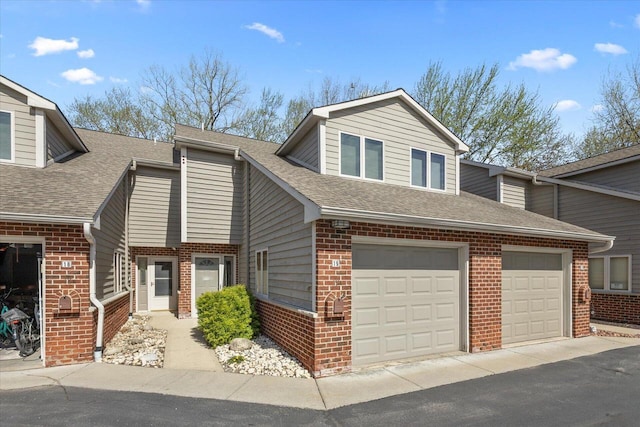view of front of house with brick siding and a shingled roof