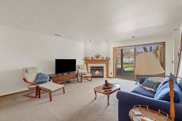 carpeted living room with baseboards and a tile fireplace