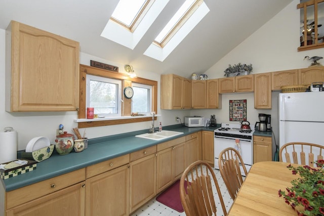 kitchen featuring a sink, light brown cabinetry, a skylight, and white appliances