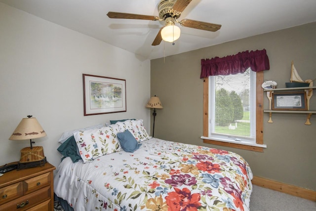 carpeted bedroom with baseboards and a ceiling fan