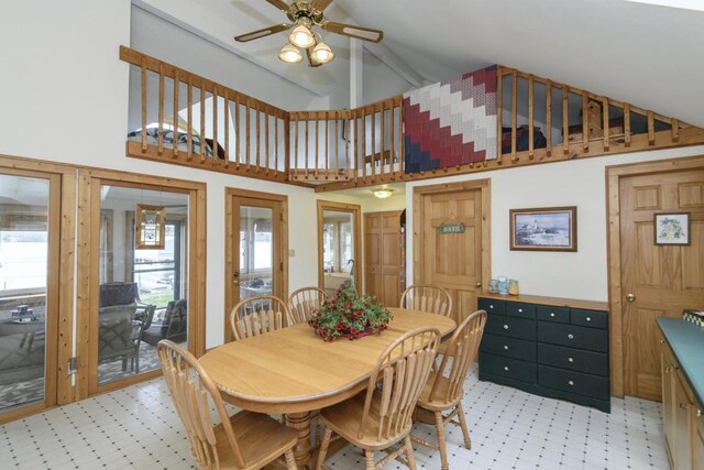 dining room featuring light floors, ceiling fan, and high vaulted ceiling