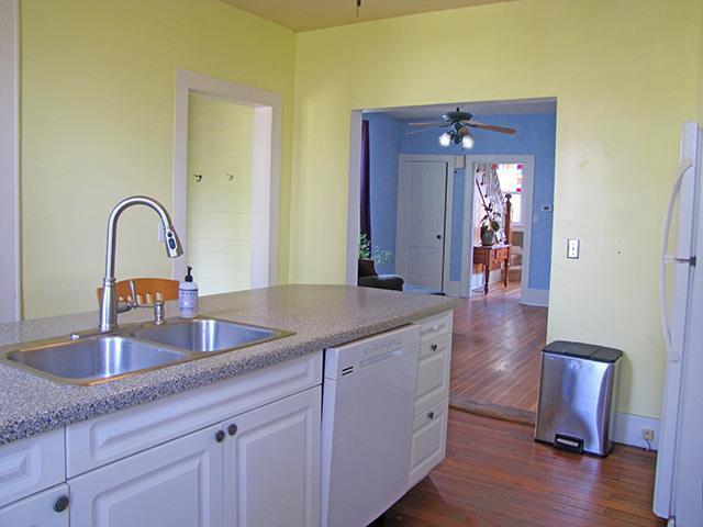 kitchen featuring a ceiling fan, dark wood-style flooring, a sink, white cabinets, and white appliances