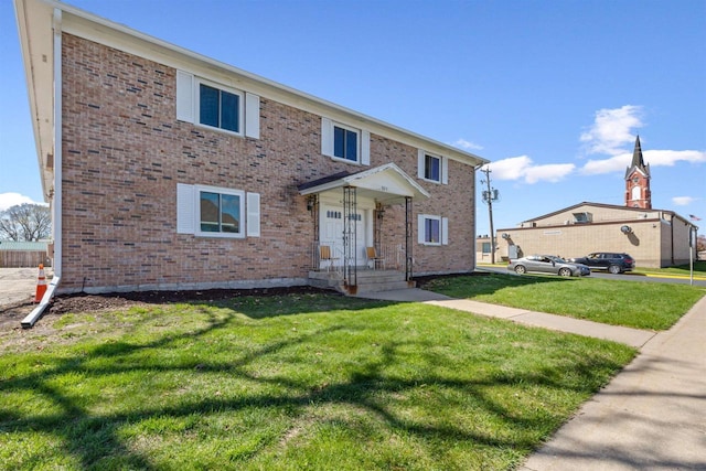 view of front facade featuring brick siding and a front lawn