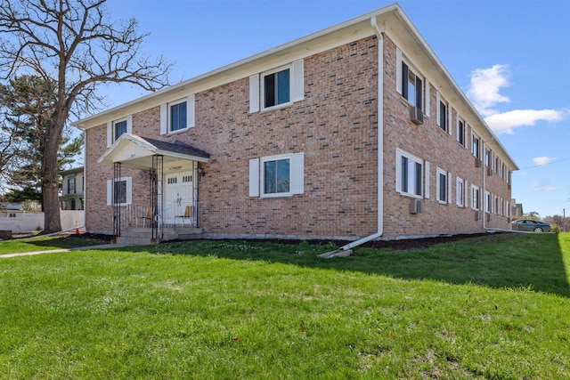 view of front of property featuring brick siding and a front lawn