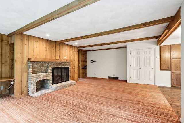 S9073 Timbercrest Trl, Prairie Du Sac, WI 53578 - unfurnished living room with beam ceiling, a fireplace, wood walls, baseboards, and recessed lighting