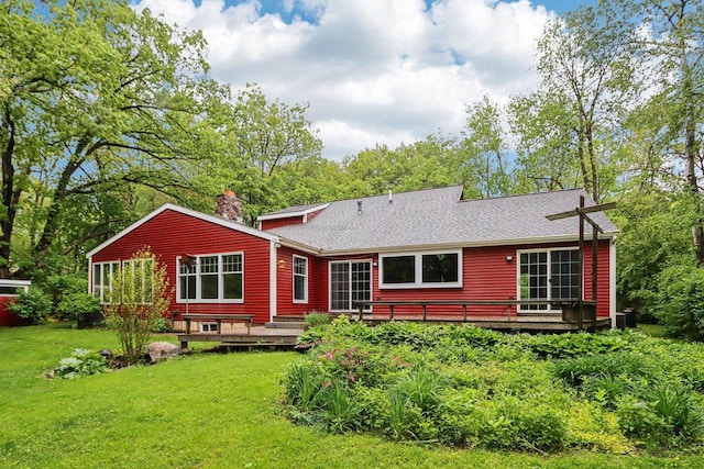 S9073 Timbercrest Trl, Prairie Du Sac, WI 53578 - back of property with a wooden deck, a lawn, a chimney, and a shingled roof
