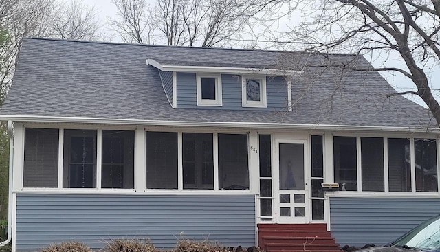bungalow featuring entry steps, a shingled roof, and a sunroom