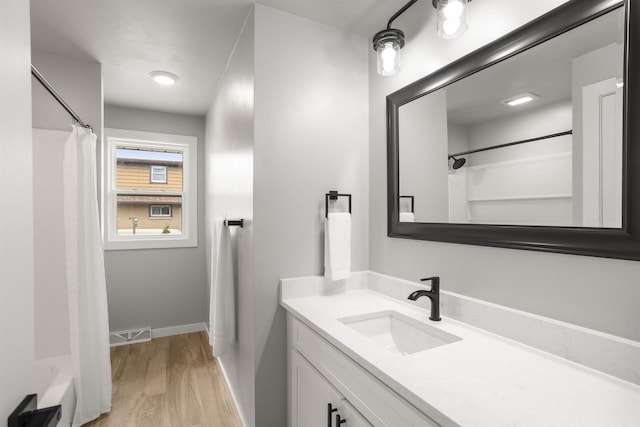 full bathroom with baseboards, visible vents, wood finished floors, and vanity