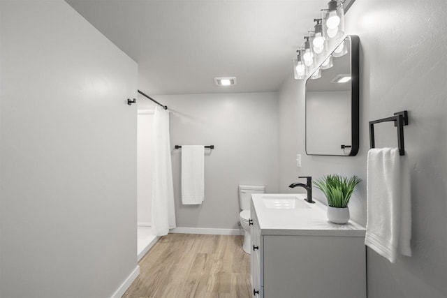 full bathroom featuring a shower with shower curtain, toilet, baseboards, and wood finished floors