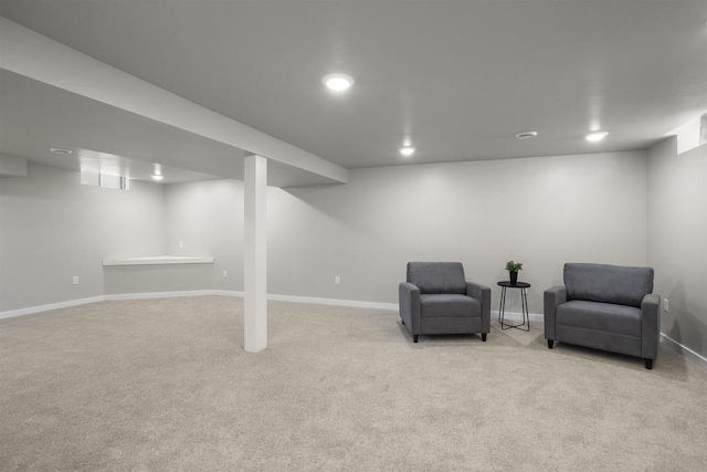 living area featuring baseboards and light colored carpet