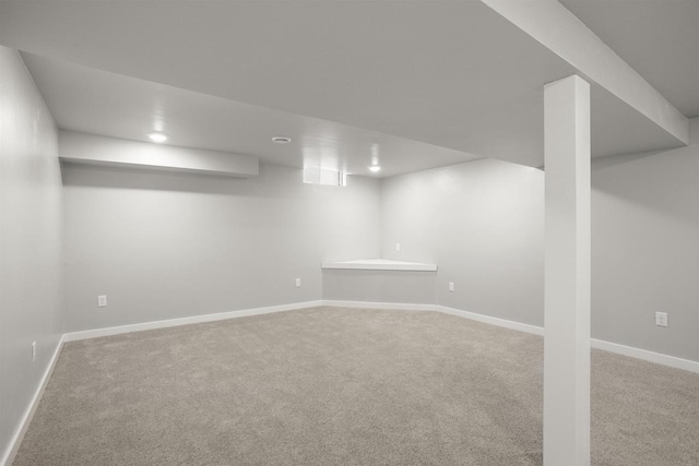 finished below grade area featuring baseboards and carpet