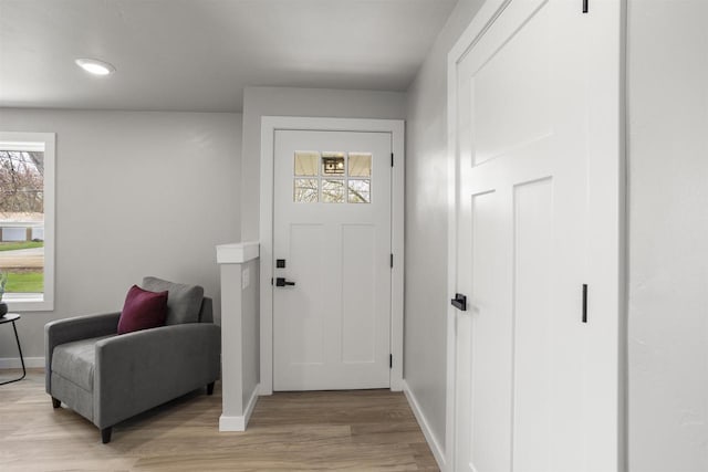 entryway with baseboards, recessed lighting, light wood finished floors, and a wealth of natural light