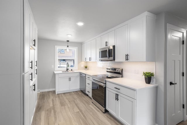 kitchen featuring a sink, light countertops, stainless steel appliances, white cabinetry, and tasteful backsplash
