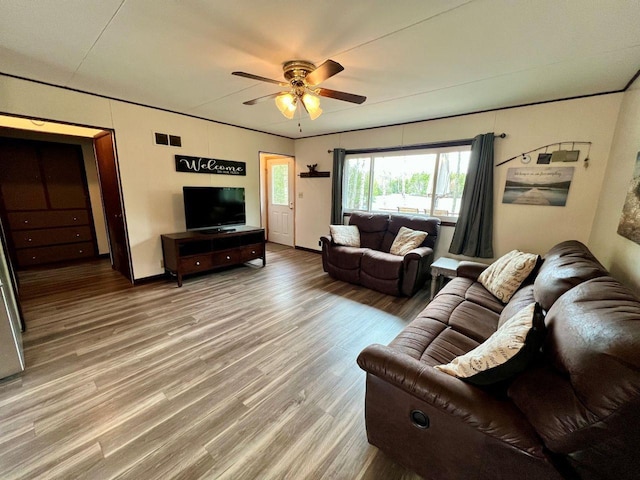 living area featuring baseboards, a ceiling fan, wood finished floors, and visible vents