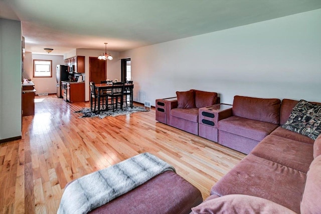 511 Linda Rd, Mount Horeb, WI 53572 - living room featuring a chandelier, light wood-type flooring, and baseboards