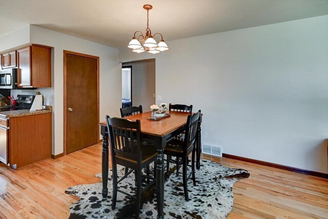 511 Linda Rd, Mount Horeb, WI 53572 - dining space featuring light wood finished floors, baseboards, and a chandelier