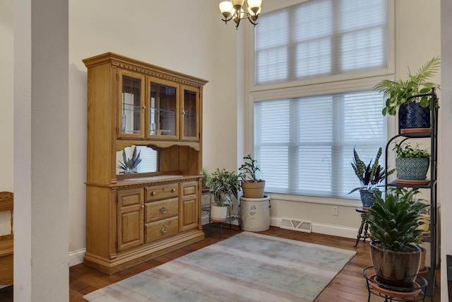 sitting room featuring visible vents, baseboards, wood finished floors, and a notable chandelier
