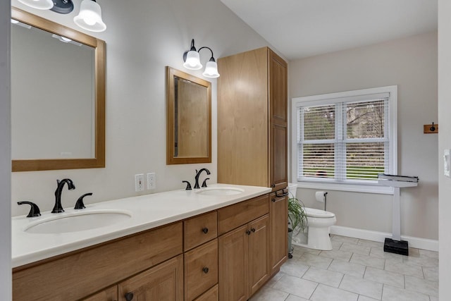 full bath featuring double vanity, toilet, tile patterned floors, and a sink