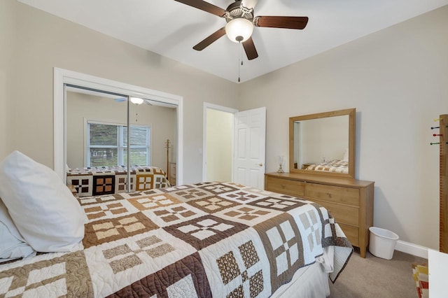bedroom with light colored carpet, a ceiling fan, baseboards, and a closet