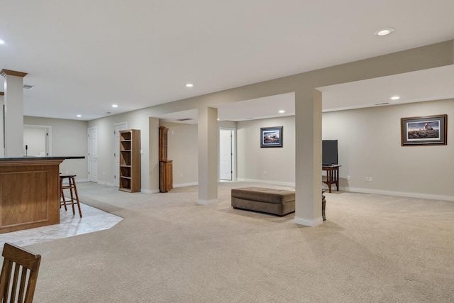 finished below grade area featuring indoor wet bar, recessed lighting, baseboards, and light carpet
