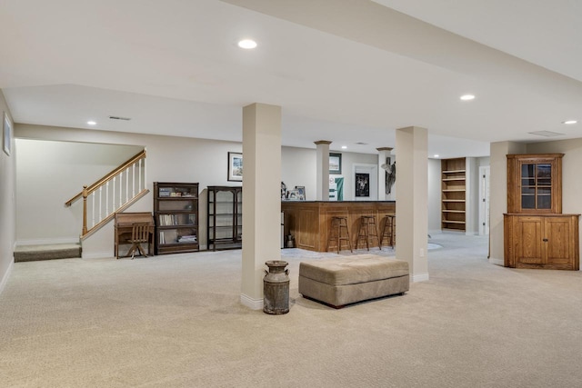 carpeted living area with stairs, indoor bar, baseboards, and recessed lighting