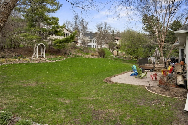 view of yard featuring a patio, fence, and a residential view
