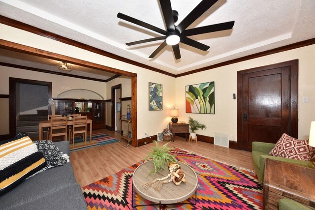 3613 N 19th St, Milwaukee, WI 53206 - living room featuring visible vents, baseboards, crown molding, and wood finished floors