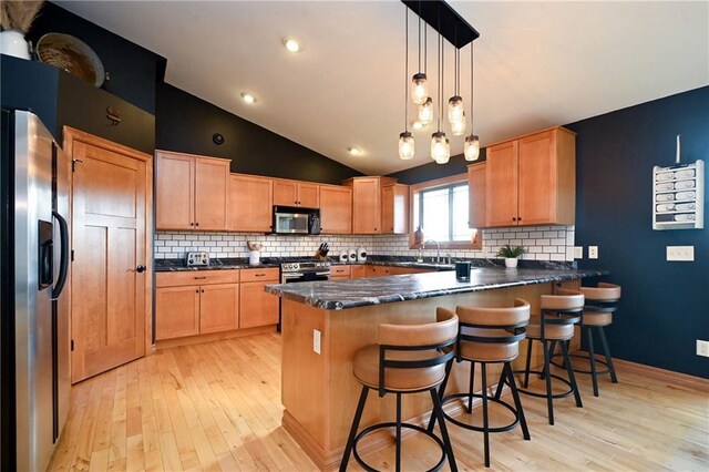 4410 Echo Valley Dr, Eau Claire, WI 54701 - kitchen with a peninsula, light wood finished floors, appliances with stainless steel finishes, and decorative backsplash
