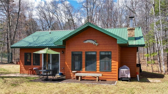 7540 Spider Lake Rd, Iron River, WI 54847 - rear view of house featuring a lawn, a patio, a chimney, and metal roof