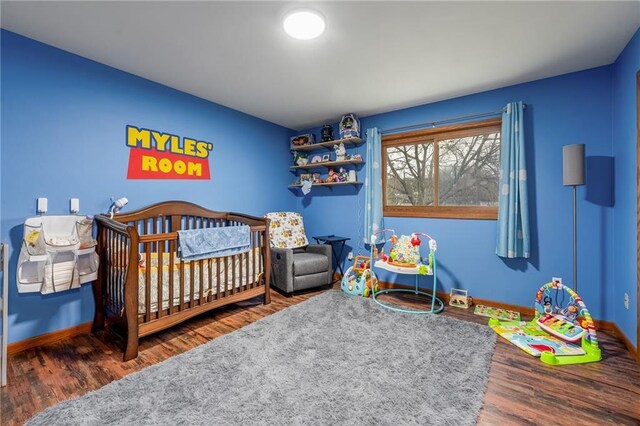 3434 Hester St, Eau Claire, WI 54701 - bedroom featuring baseboards, a crib, and wood finished floors