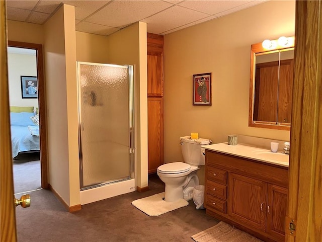 bathroom featuring vanity, a drop ceiling, a stall shower, and toilet