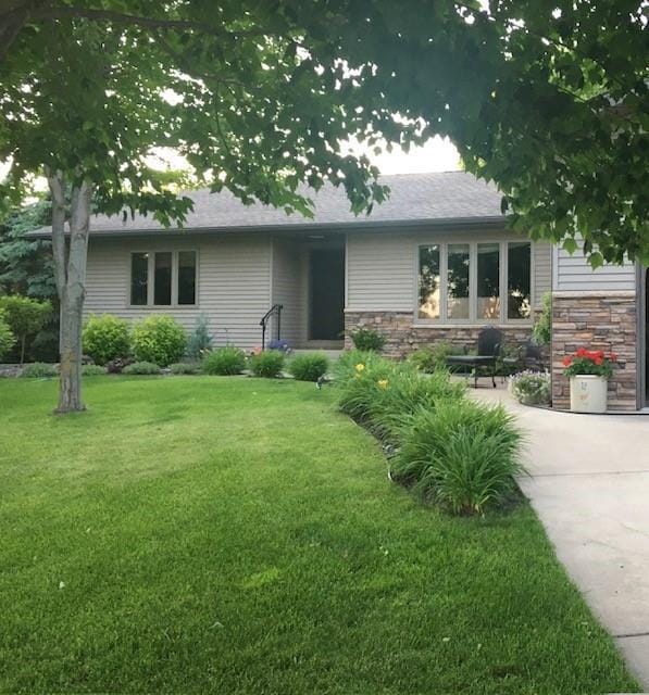 view of front of home featuring stone siding and a front yard