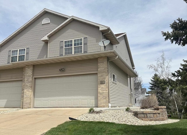 555 Kelvington Dr Unit 4, Sun Prairie, WI 53590 - view of front facade featuring an attached garage, brick siding, and driveway