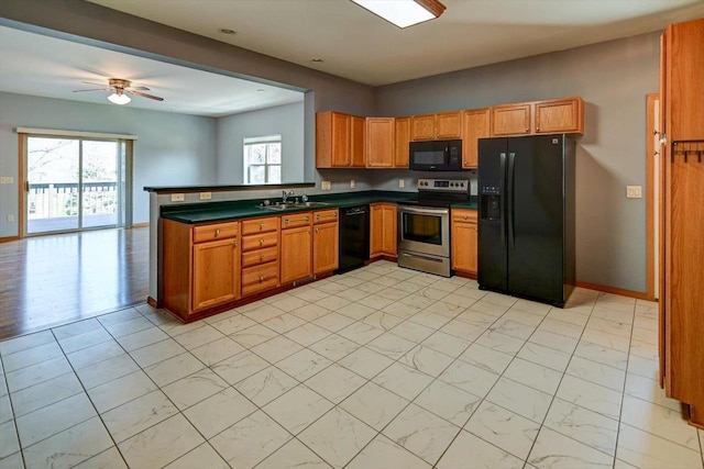 555 Kelvington Dr Unit 4, Sun Prairie, WI 53590 - kitchen with black appliances, a sink, dark countertops, a peninsula, and ceiling fan