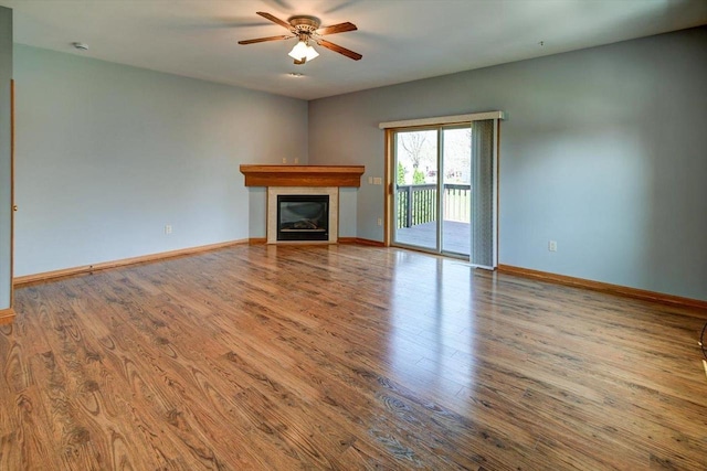 555 Kelvington Dr Unit 4, Sun Prairie, WI 53590 - unfurnished living room with a ceiling fan, wood finished floors, a glass covered fireplace, and baseboards